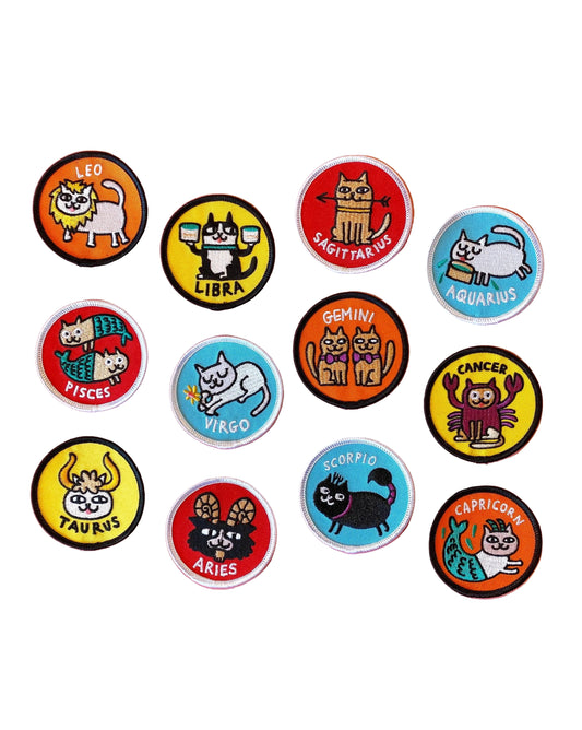 Set of zodiac-themed buttons with cartoon animals on a pink background