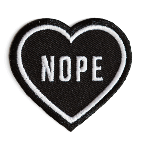 Black heart-shaped patch with 'NOPE' text on a white background