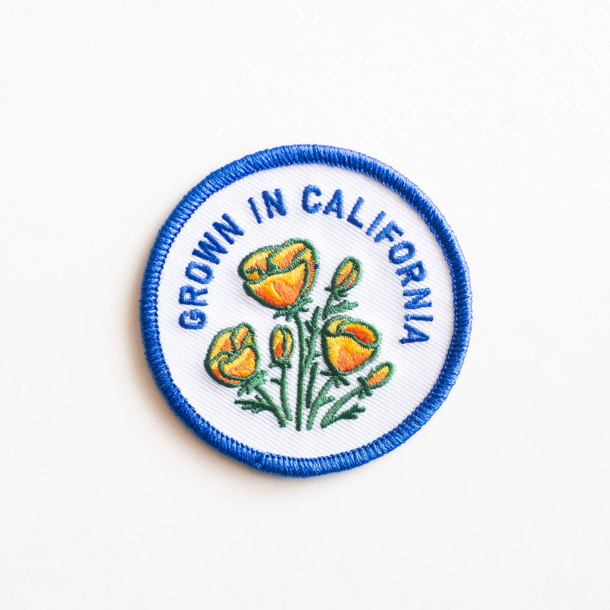 Embroidered patch with flowers and 'Grown in California' text on a white background