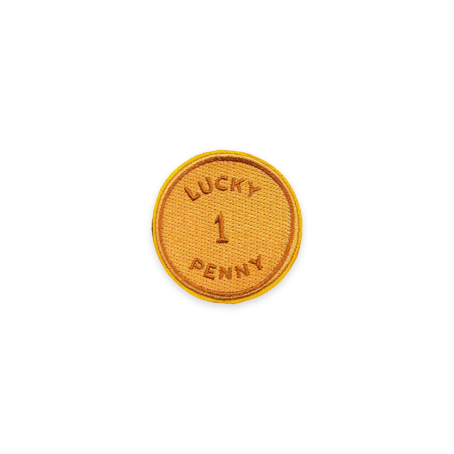 A circular embroidered patch with a golden-yellow border and a textured orange-brown center, featuring the text 'LUCKY 1 PENNY' embroidered in matching thread on a plain white background.