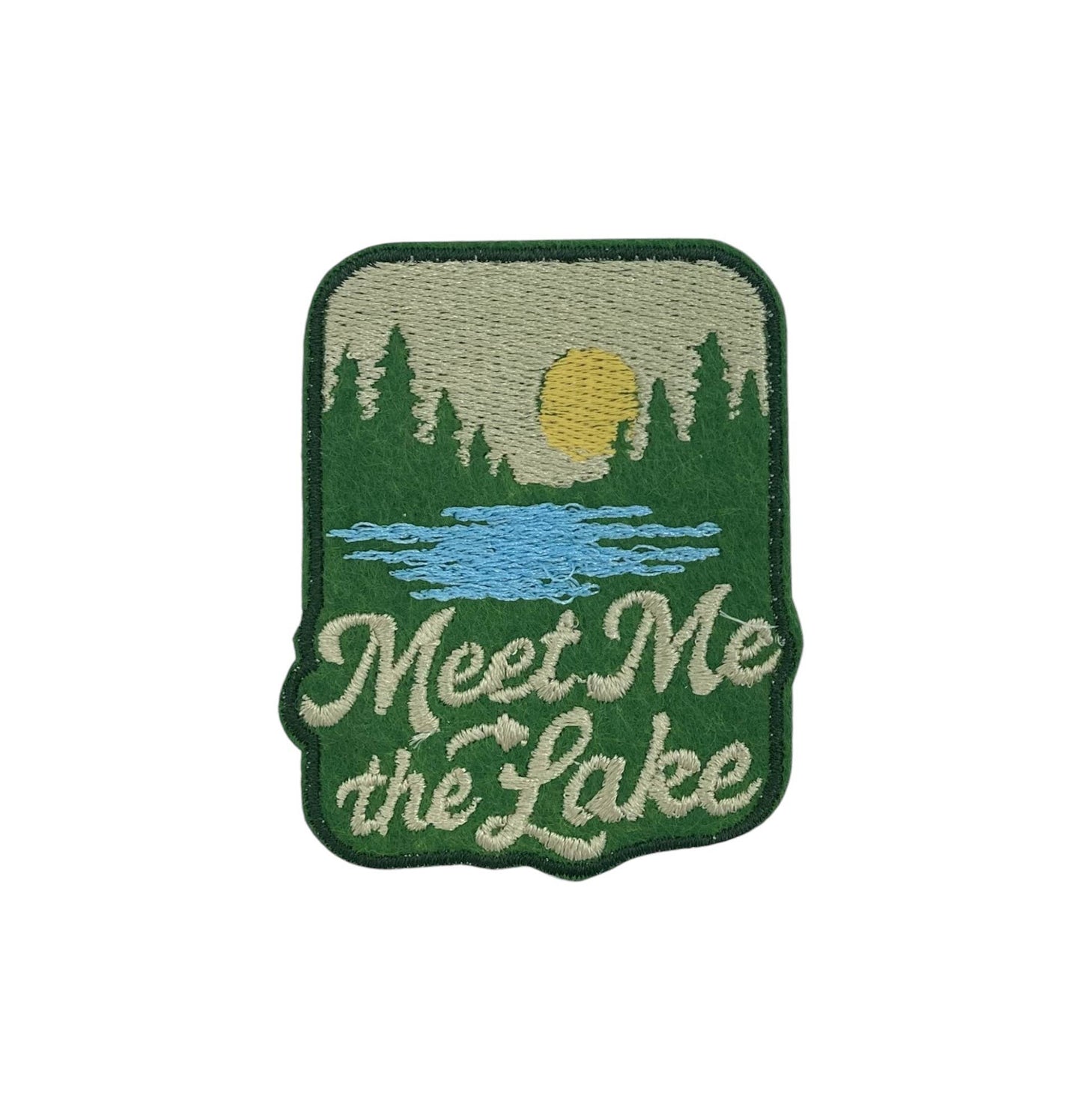 Embroidered patch with a lake and forest design and 'Meet Me at the Lake' text on a white background.