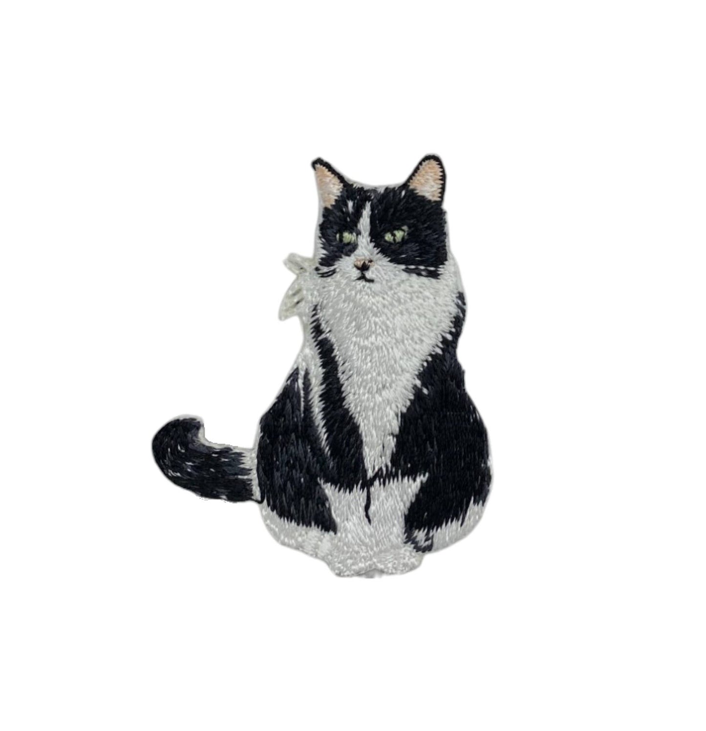 Black and white cat-shaped plush toy on a white background