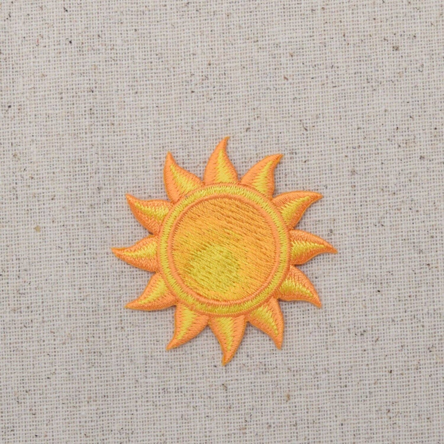 Embroidered sun patch on a textured fabric background