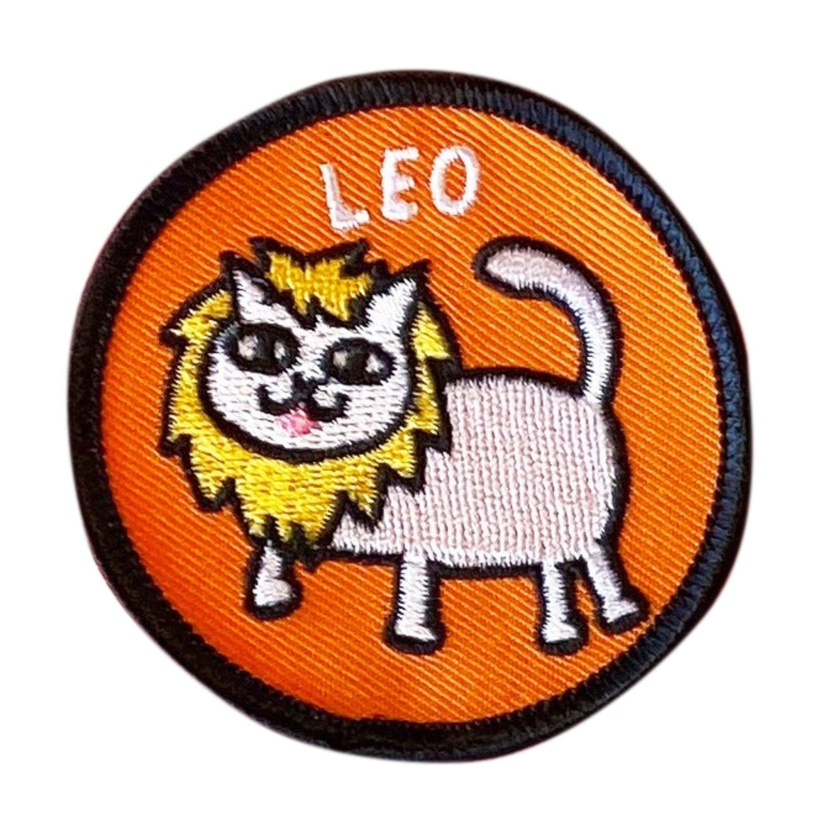 A circular embroidered patch featuring a cartoon lion cat with a white body, yellow mane, and black outlines on an orange background, with the word 'LEO' stitched at the top.