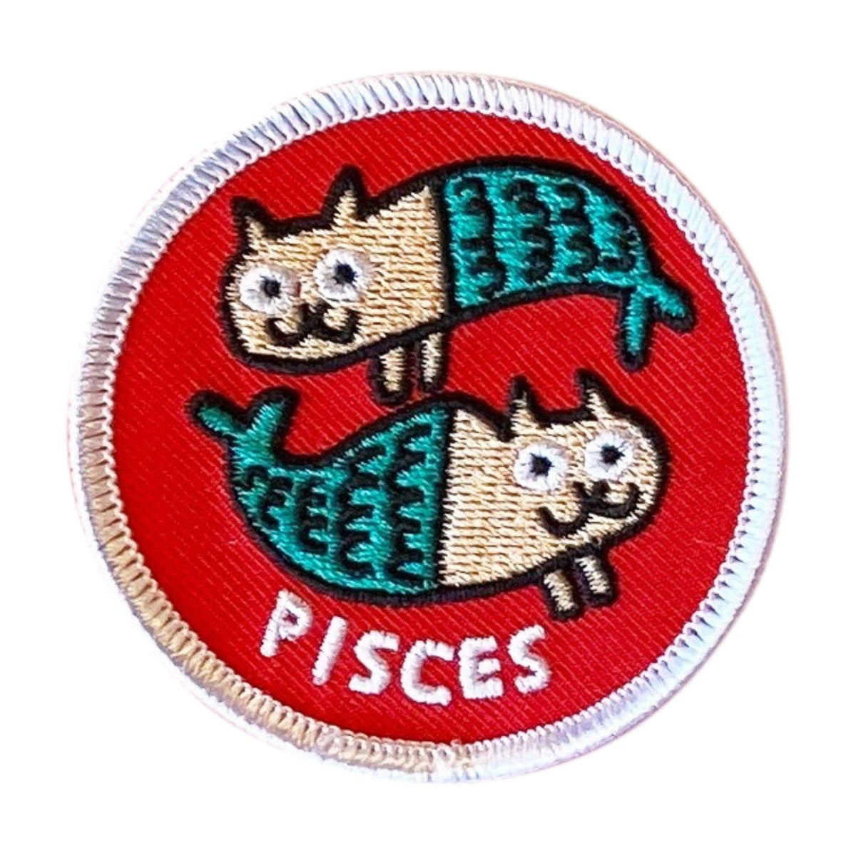 A circular embroidered patch featuring two cartoon fish with cat faces on a red background, with the word 'PISCES' stitched in white at the bottom. The patch has a white merrowed border.