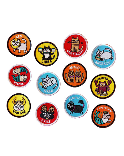 Set of zodiac-themed buttons with cartoon animals on a pink background
