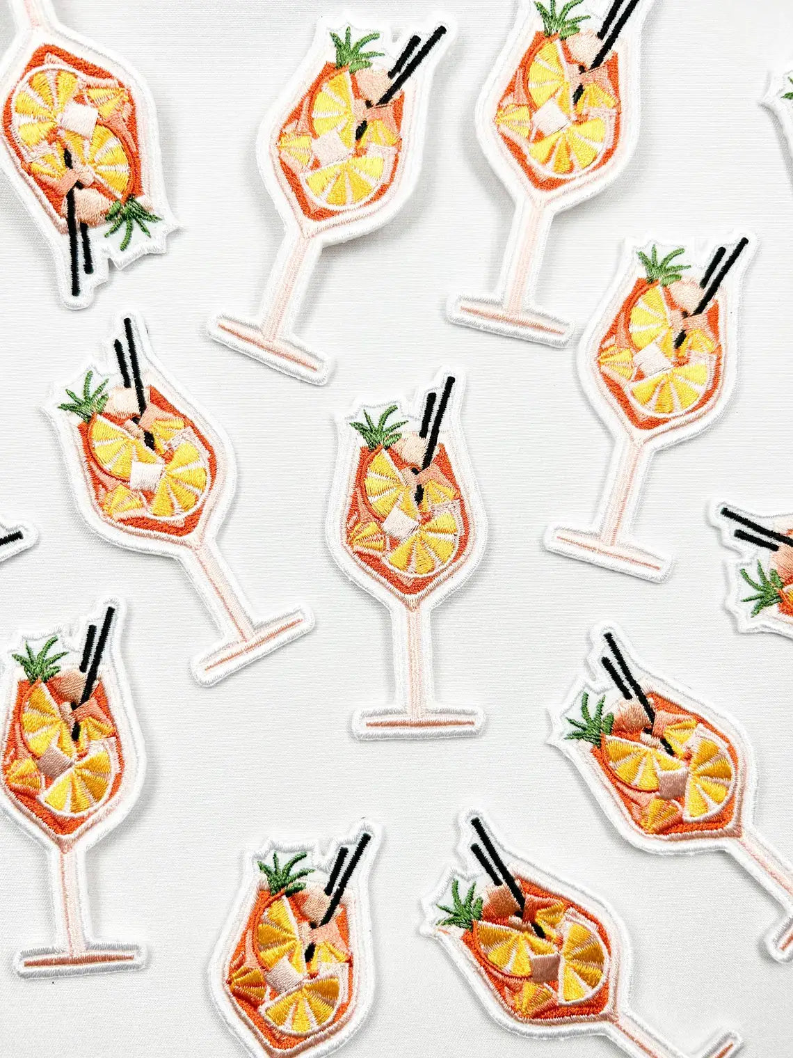 Pattern of cocktail glass stickers with pineapple and orange slices on a white background