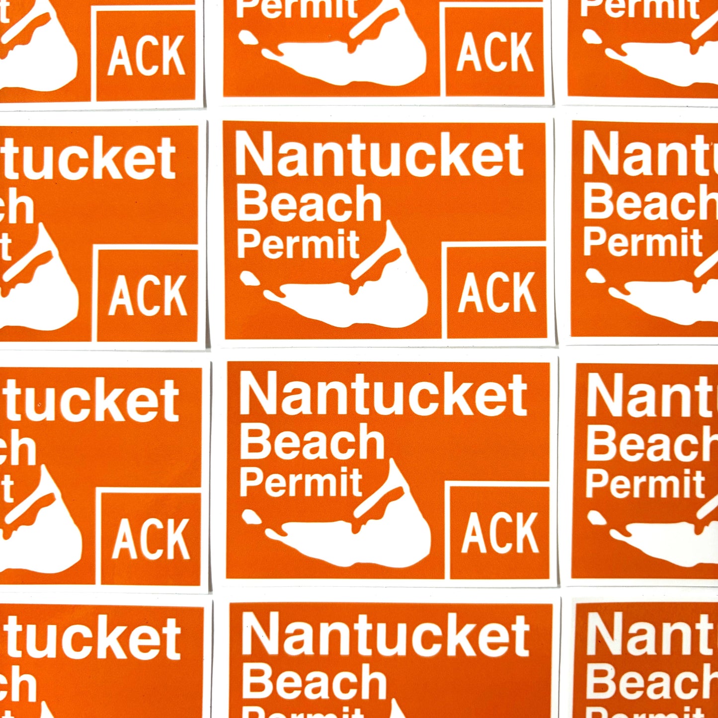 A repeating grid of orange rectangular stickers with white text reading 'Nantucket Beach Permit' and a white shell icon, with 'ACK' also visible in one block.