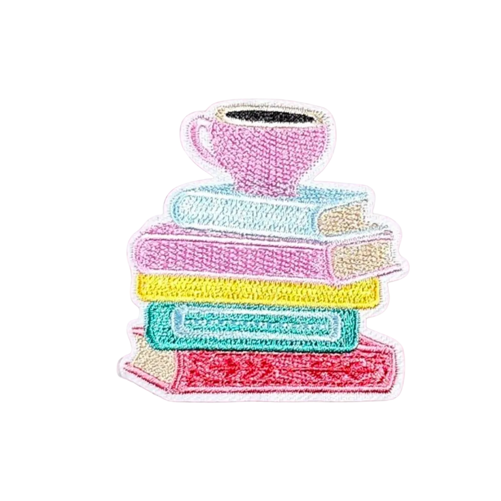 Embroidered patch of books and a teacup on white fabric
