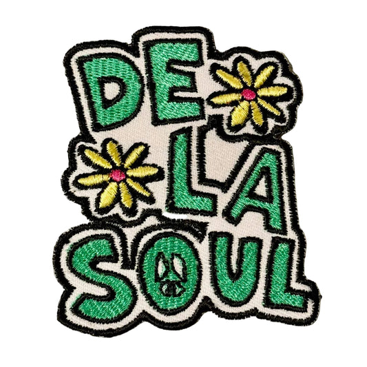 Embroidered patch with 'DE LA SOUL' text and flowers on a gray fabric background