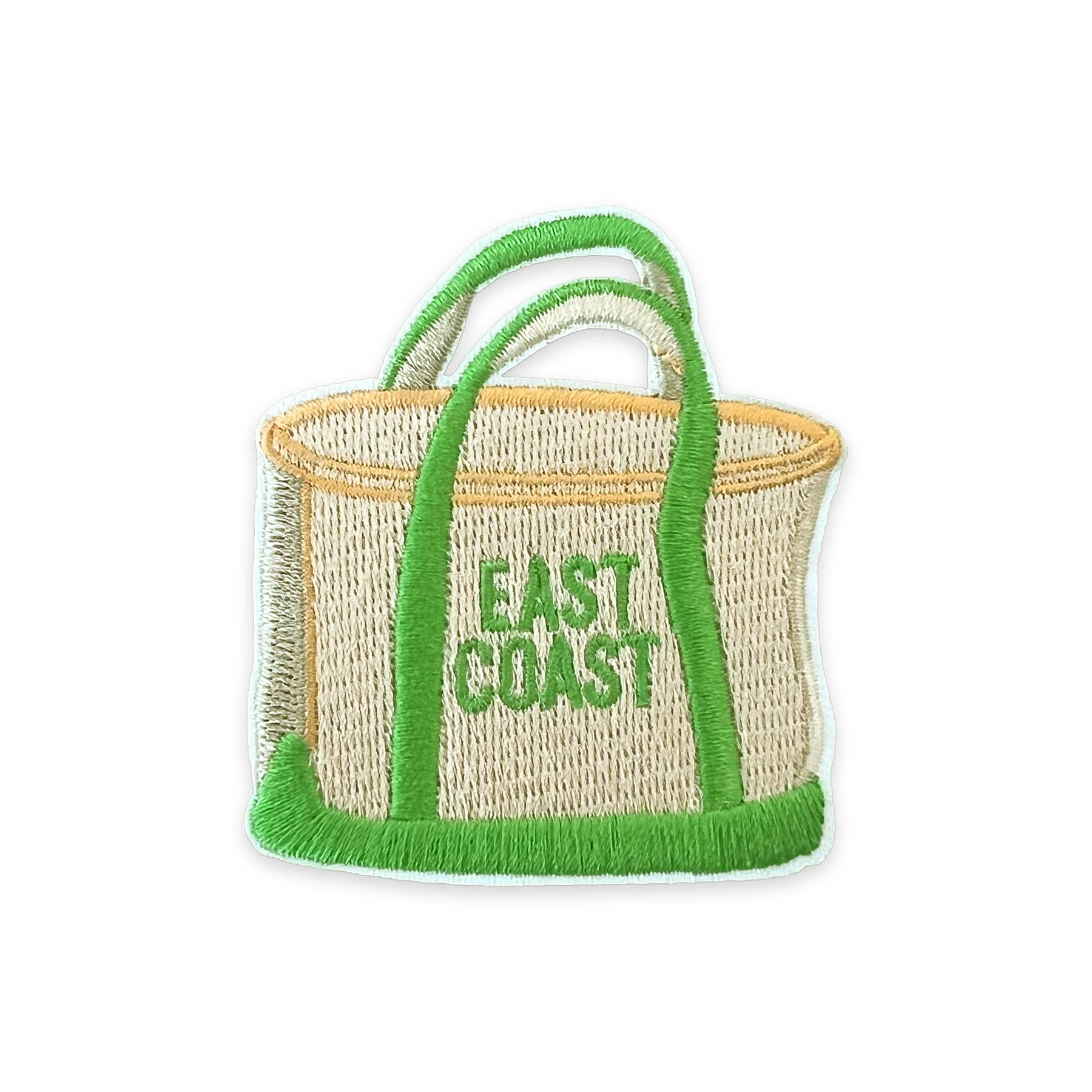 A woven straw tote bag with bright green handles, trim, and fringe, featuring the words 'EAST COAST' embroidered in green on the front, isolated on a white background.