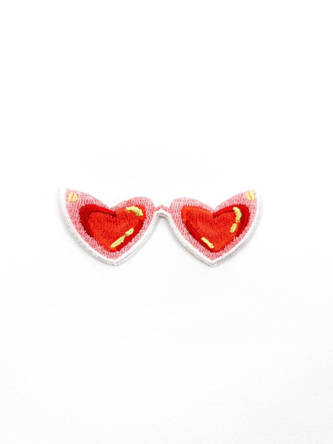Heart-shaped earrings with red hearts and yellow accents on a white background