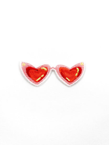 Heart-shaped earrings with red hearts and yellow accents on a white background