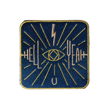 Embroidered patch with eye design and text on a blue background
