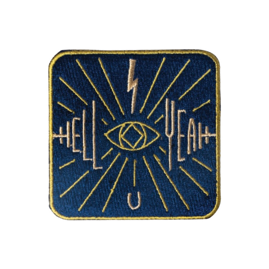 Embroidered patch with eye design and text on a blue background