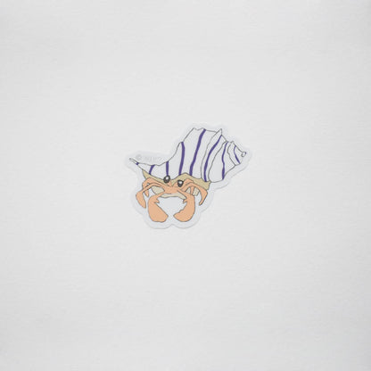 A small die-cut sticker featuring a cartoon hermit crab inside a spiral shell with purple and white stripes, centered on a plain light gray background.