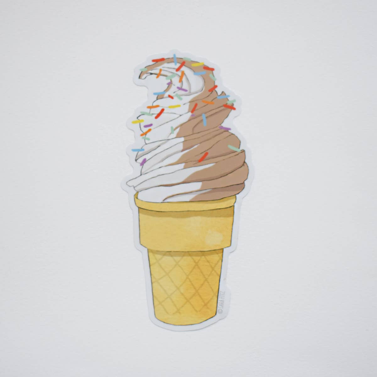 Ice cream cone with colorful sprinkles on a light gray background