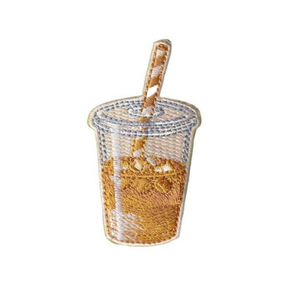 Clear plastic cup with gold confetti and a wooden spoon on a white background