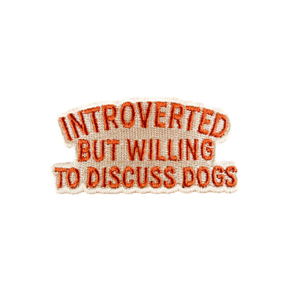 Embroidered patch with text 'Introverted but willing to discuss dogs' on a white background
