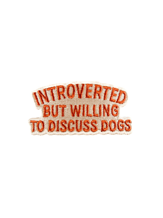 Embroidered patch with text 'Introverted but willing to discuss dogs' on a white background