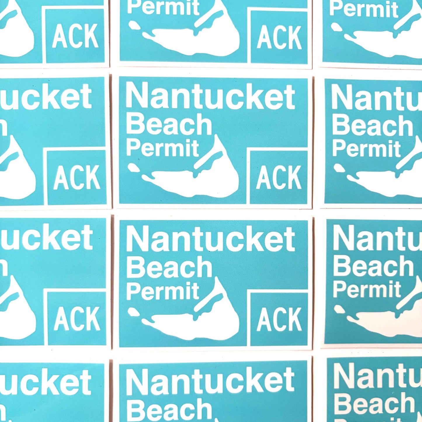 A close-up grid of identical rectangular stickers with a turquoise background, white text reading 'Nantucket Beach Permit' and 'ACK', and a white silhouette map graphic.