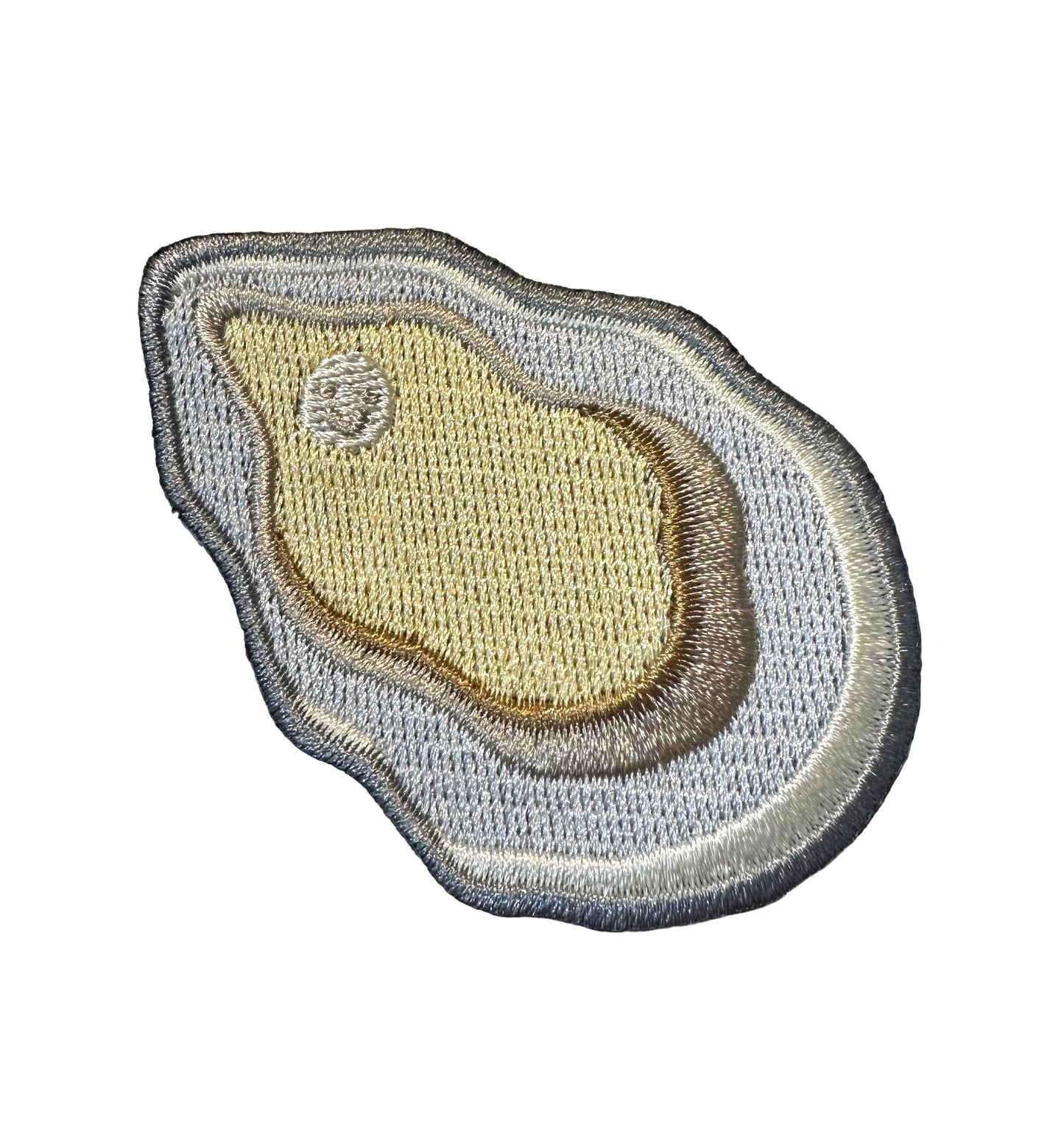 An irregularly shaped oyster embroidered patch with concentric organic borders in gray, beige, and brown tones on a plain white background.