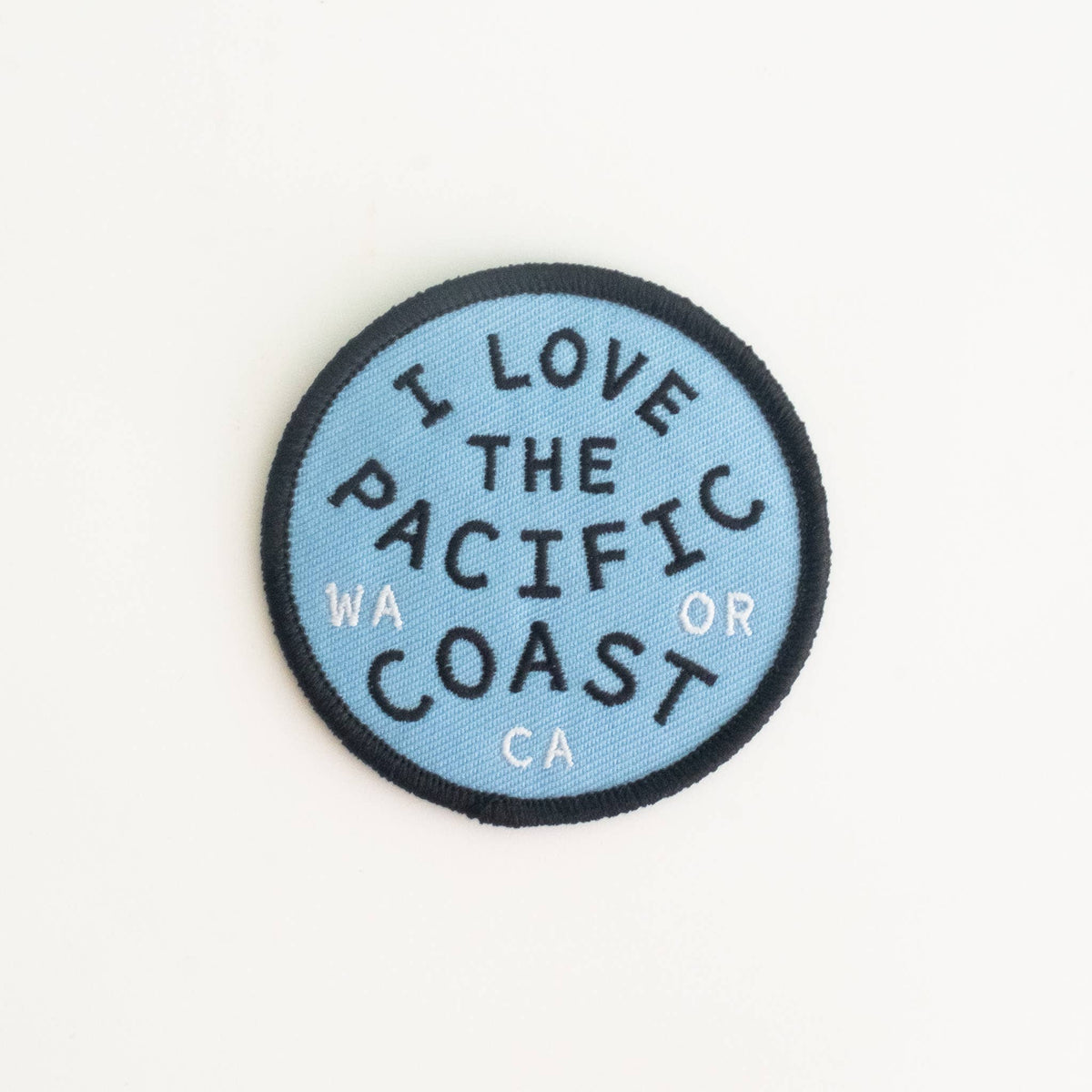Round patch with 'I Love the Pacific Coast' text on a light blue background