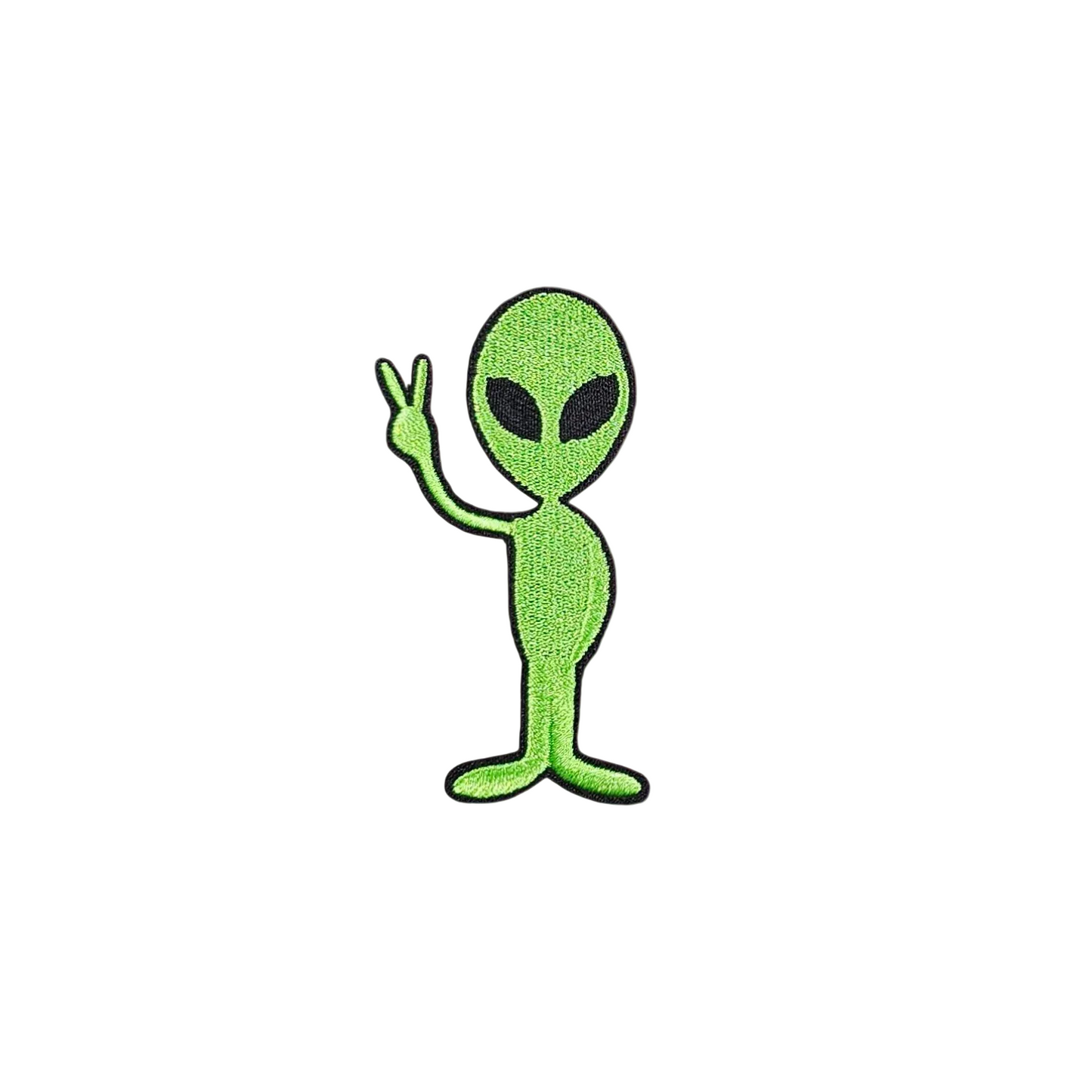 Green alien patch with a peace sign on a white fabric background