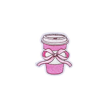 Pink coffee cup with a bow on a white textured background