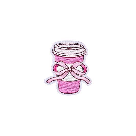 Pink coffee cup with a bow on a white textured background