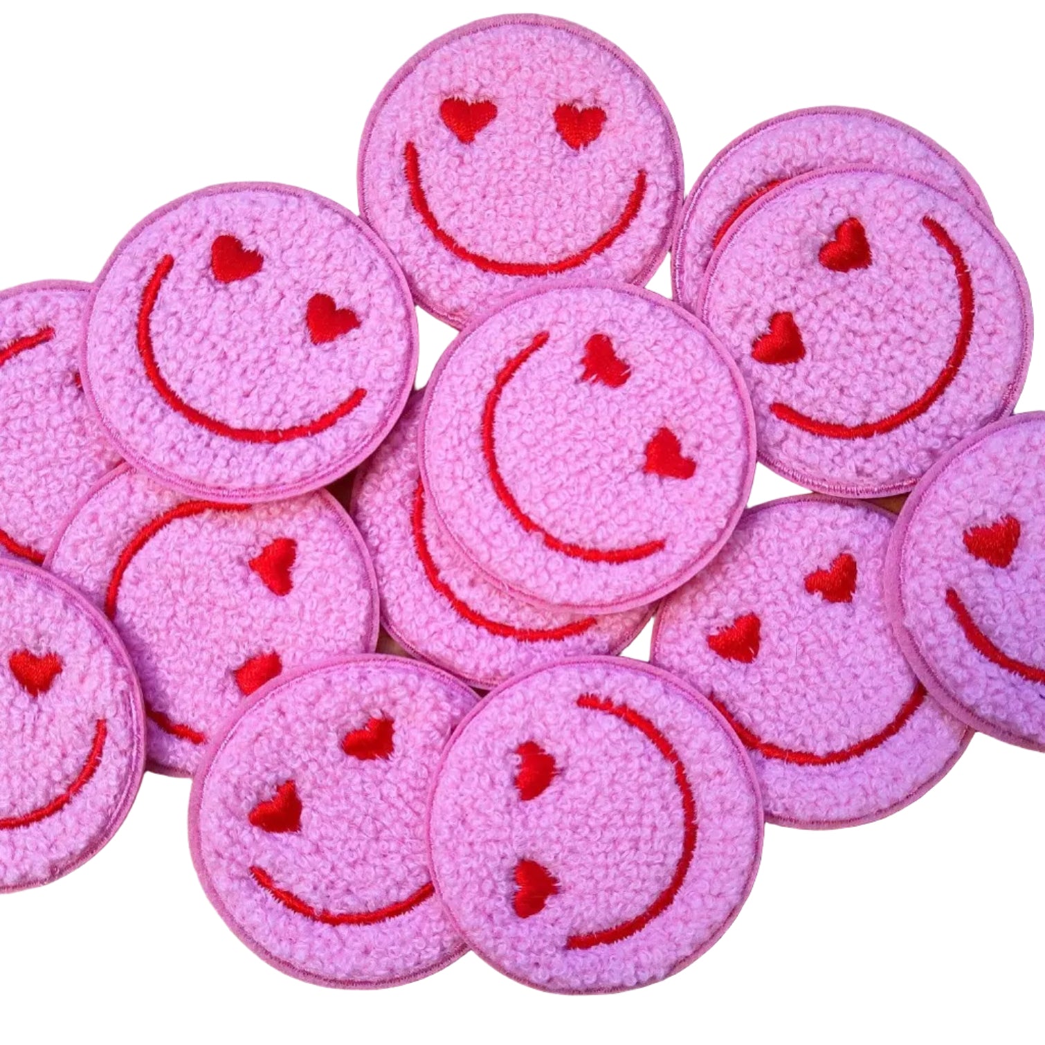 Pink smiley face patches with red outlines on a wooden surface