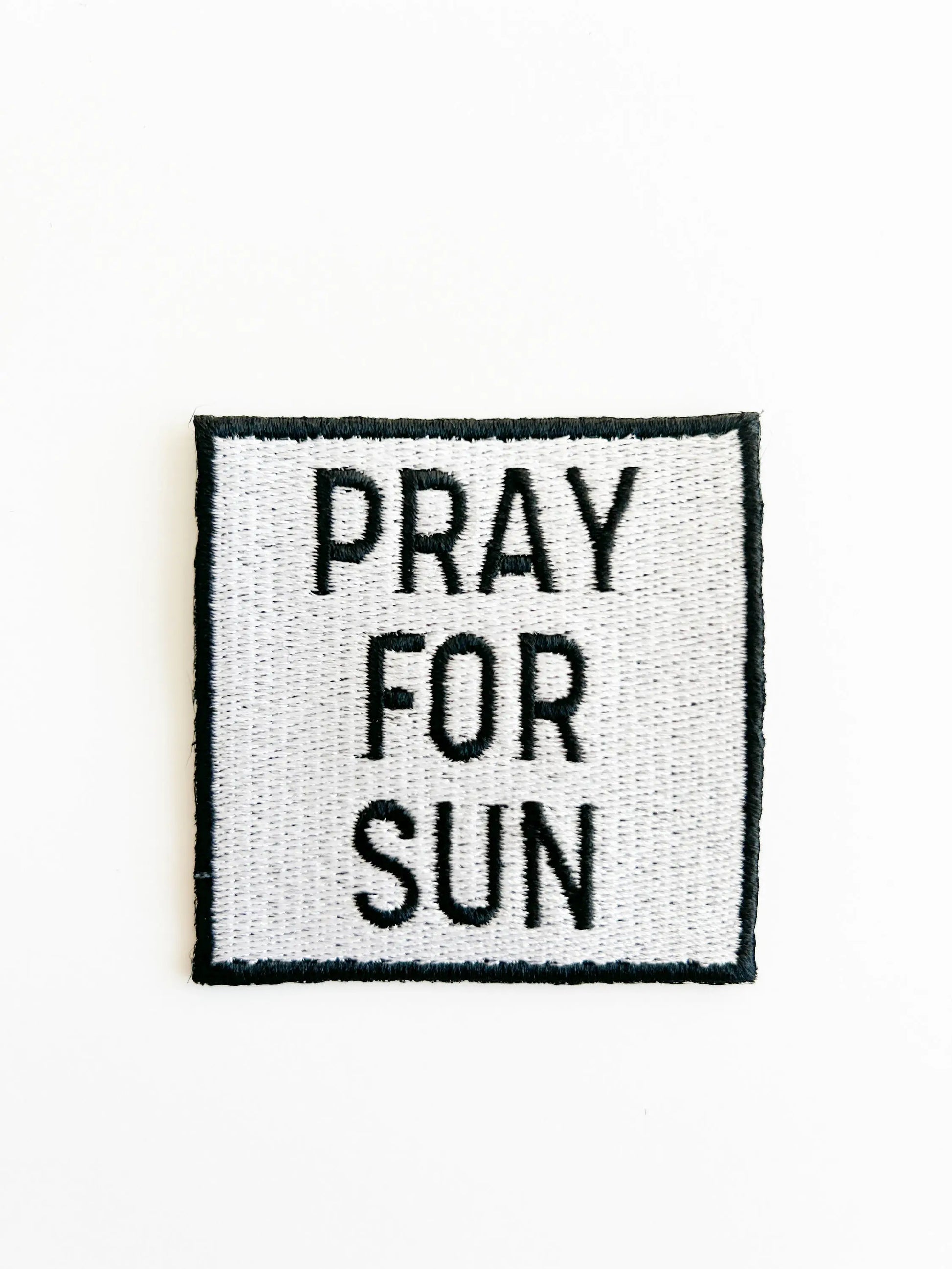 Square patch with 'PRAY FOR SUN' text on a white background