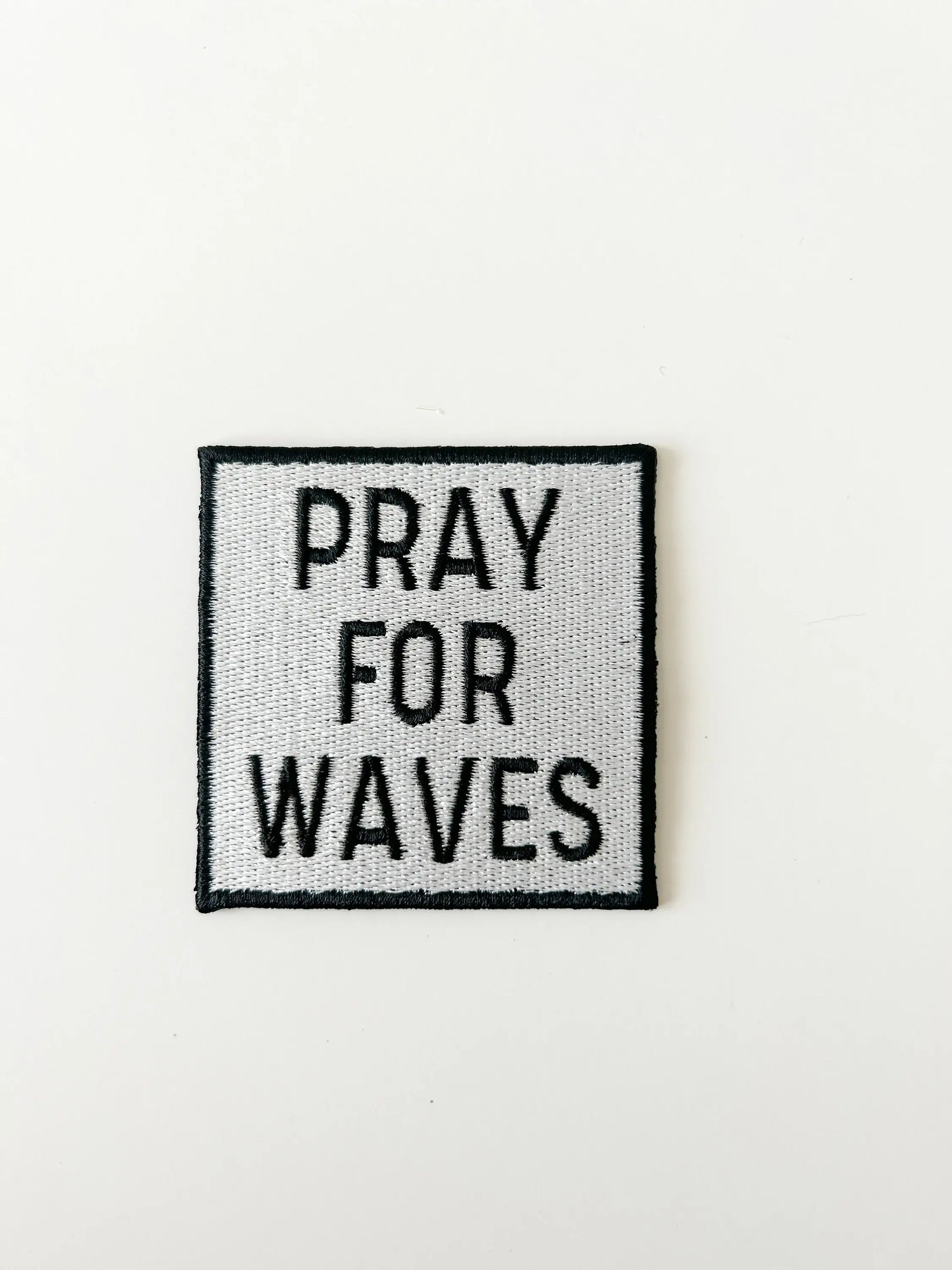 Text patch with 'PRAY FOR WAVES' on a white background