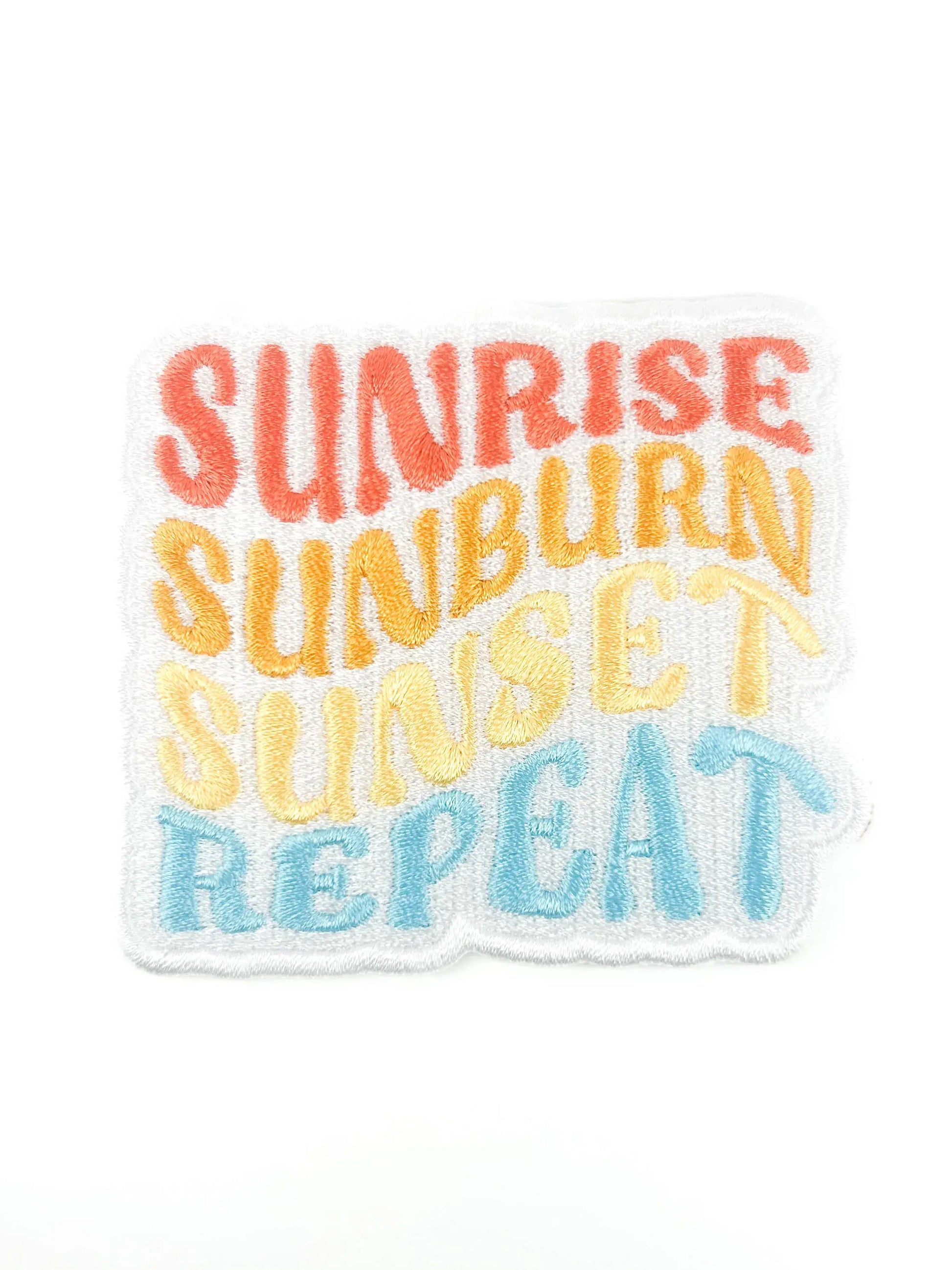 Text patch with 'Sunrise Sunburn Sunset Repeat' in colorful letters on a white background