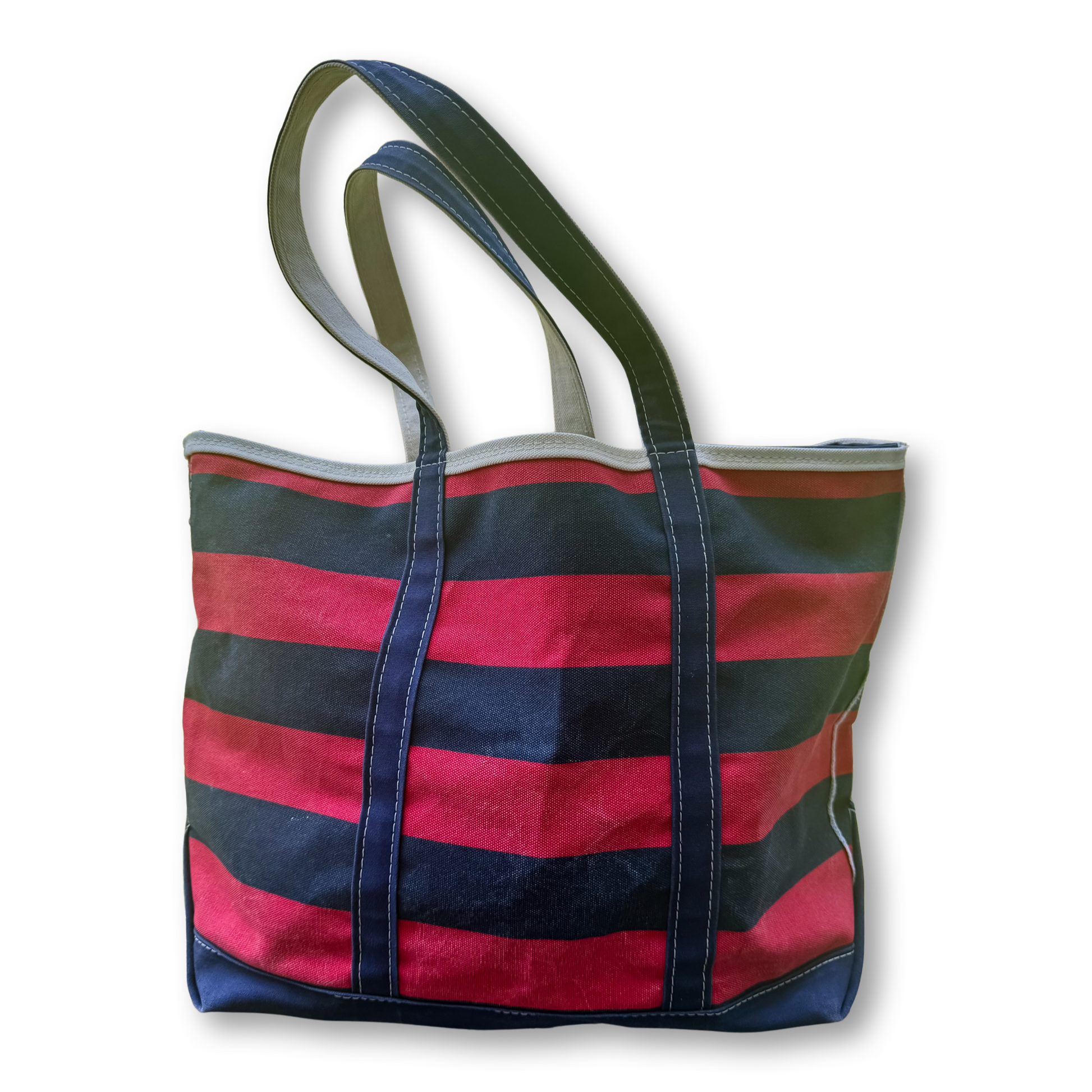 A canvas tote bag with horizontal stripes in red and dark navy blue, featuring dark green shoulder straps and a gray top trim, shown on a white background.