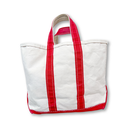White tote bag with red straps on a white background