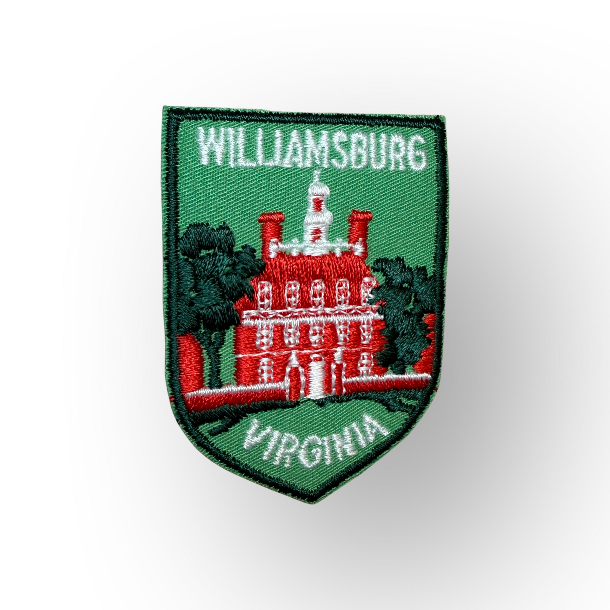 An embroidered shield-shaped patch featuring the Williamsburg, Virginia schoolhouse on a green background with white text reading 'WILLIAMSBURG' at the top and 'VIRGINIA' at the bottom.