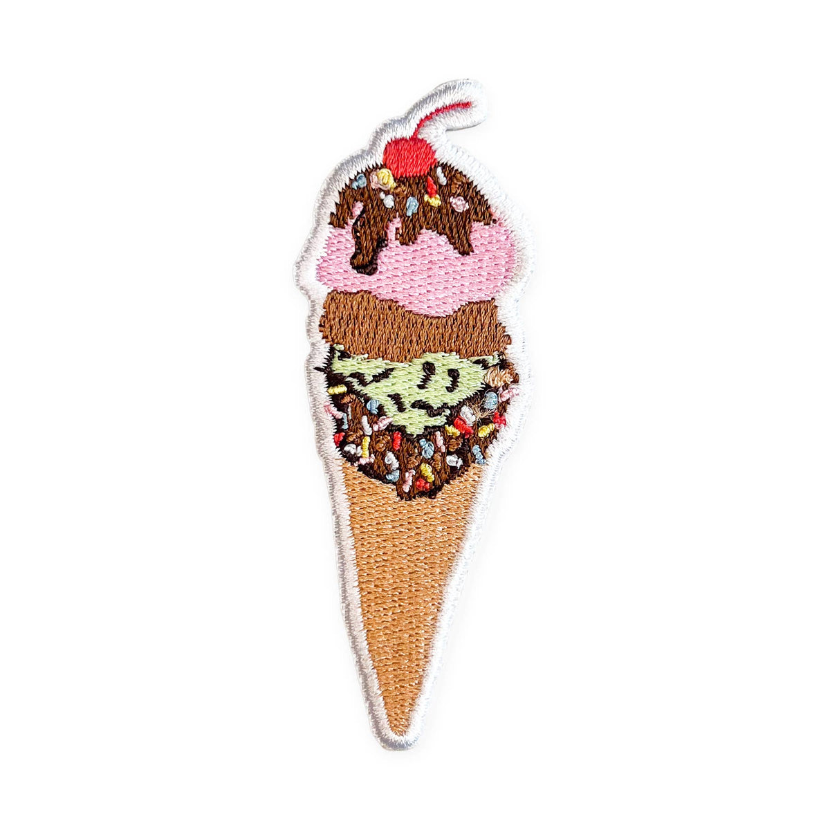 Patch of an ice cream cone with chocolate sauce, sprinkles, and a cherry on top.