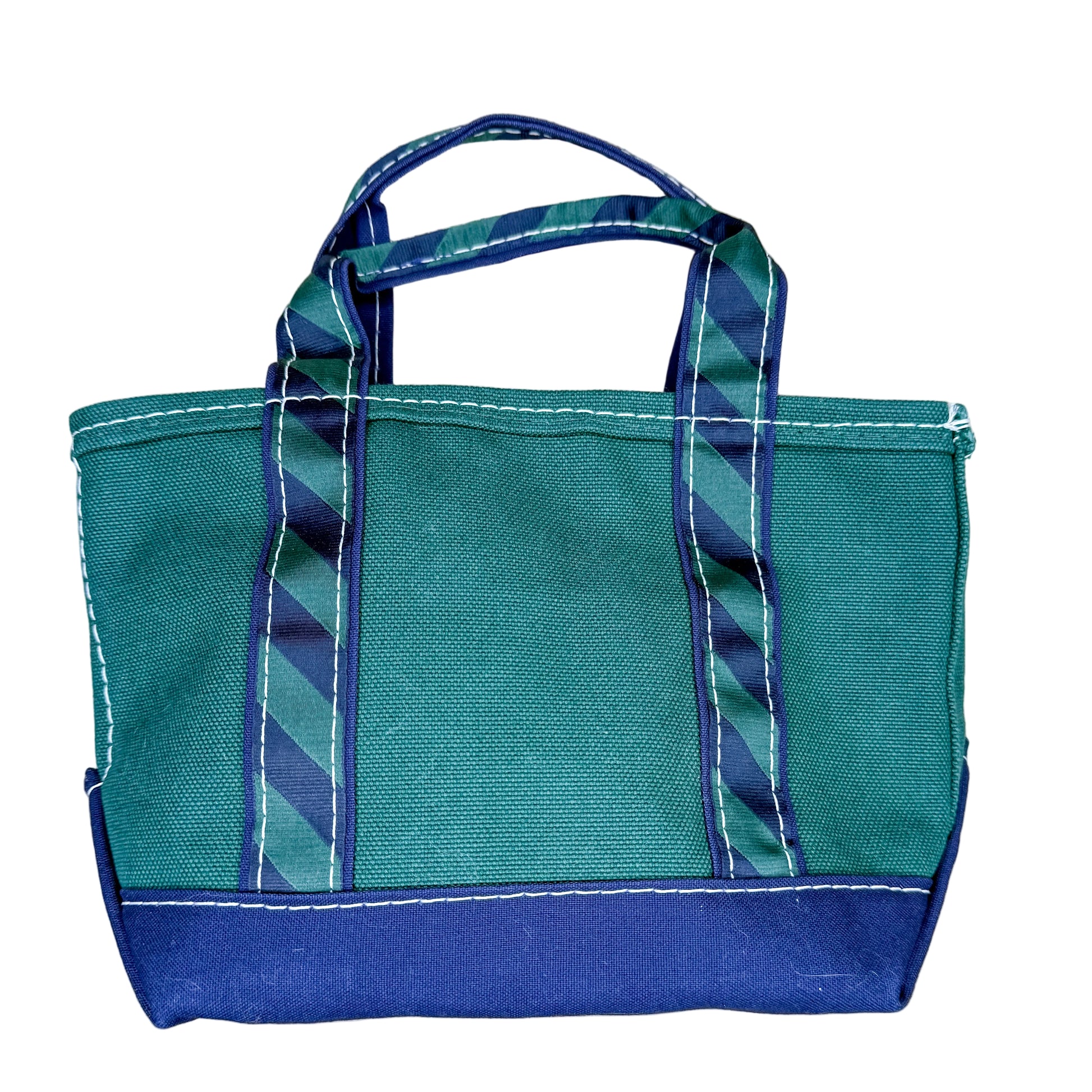 Teal and blue tote bag with striped handle on a textured white surface
