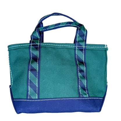 Teal and blue tote bag with striped handle on a textured white surface
