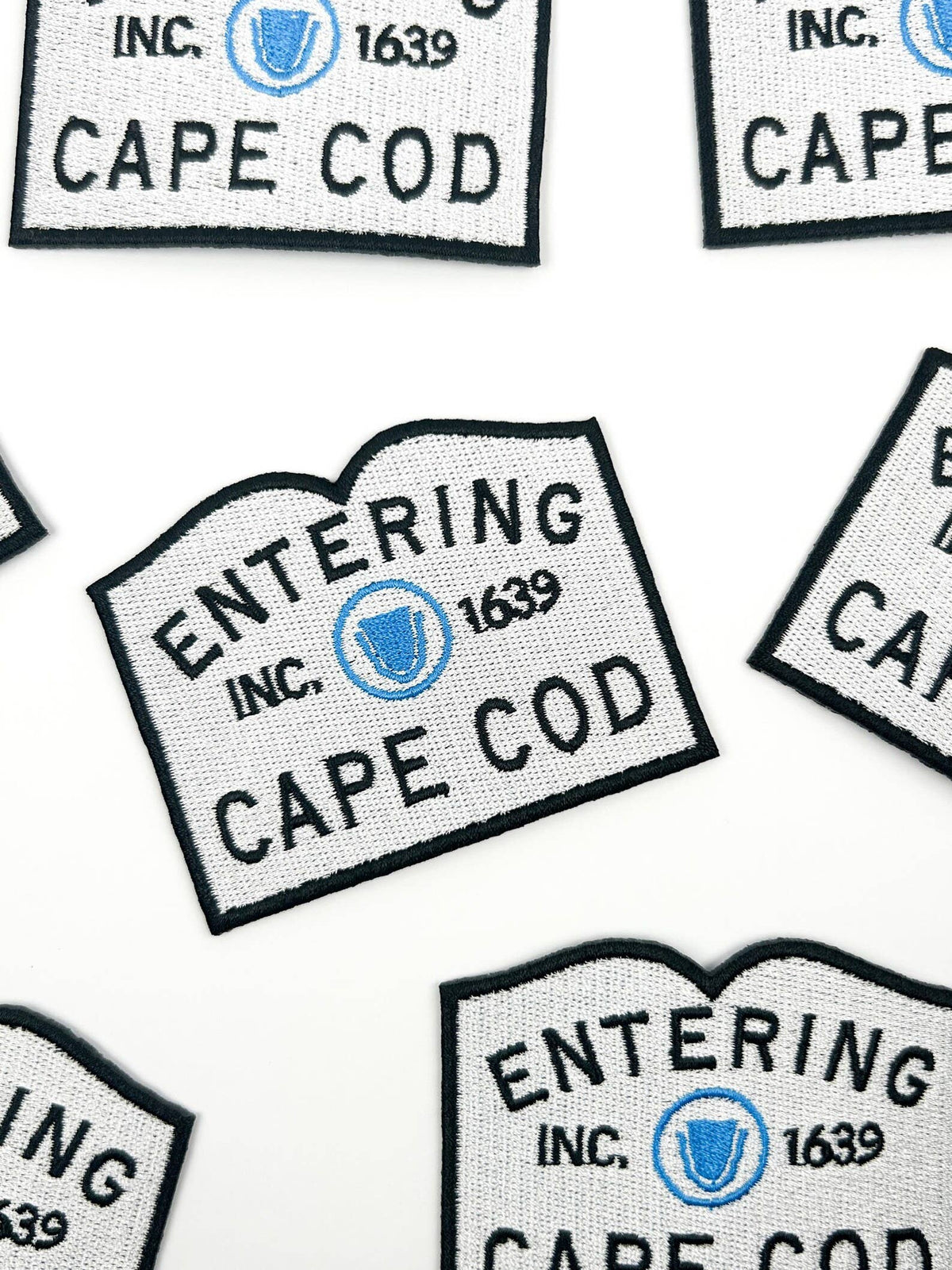 Multiple 'Entering Cape Cod' signs with a blue emblem on a white background