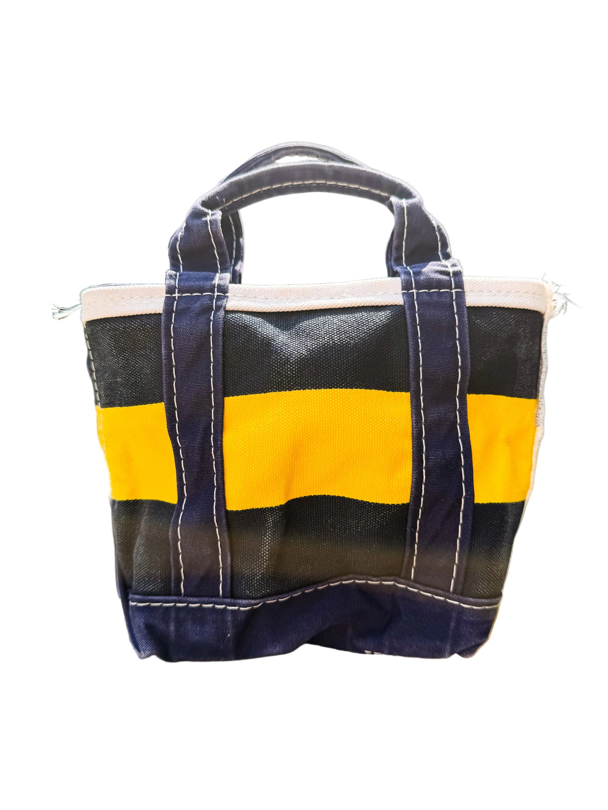 navy and yellow striped bag on a wooden surface with a blurred outdoor background