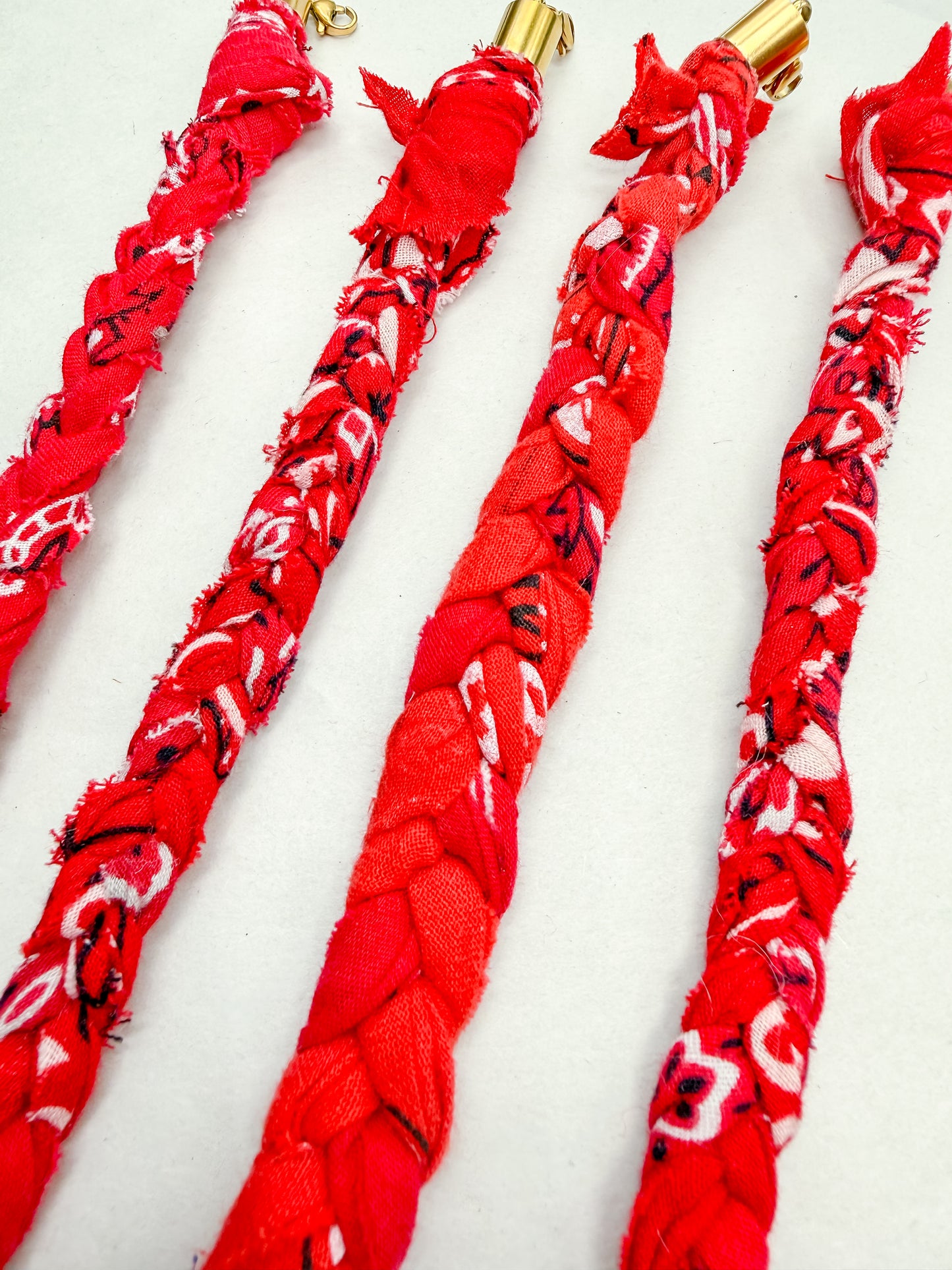 Red bandana braided hair ties on a white background