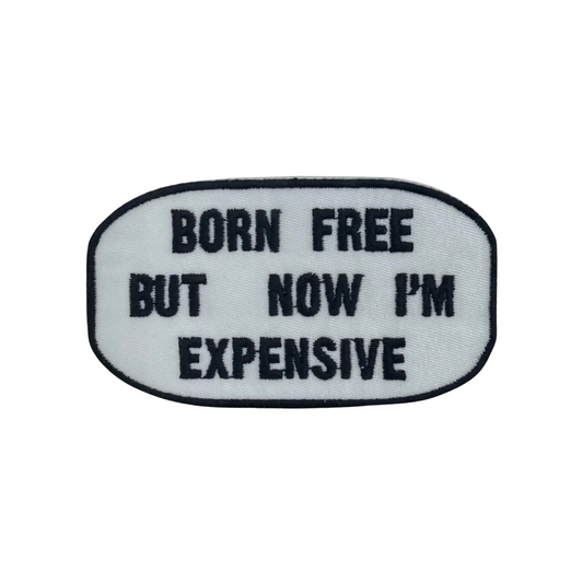 Embroidered patch with text 'Born Free But Now I'm Expensive' on a white background