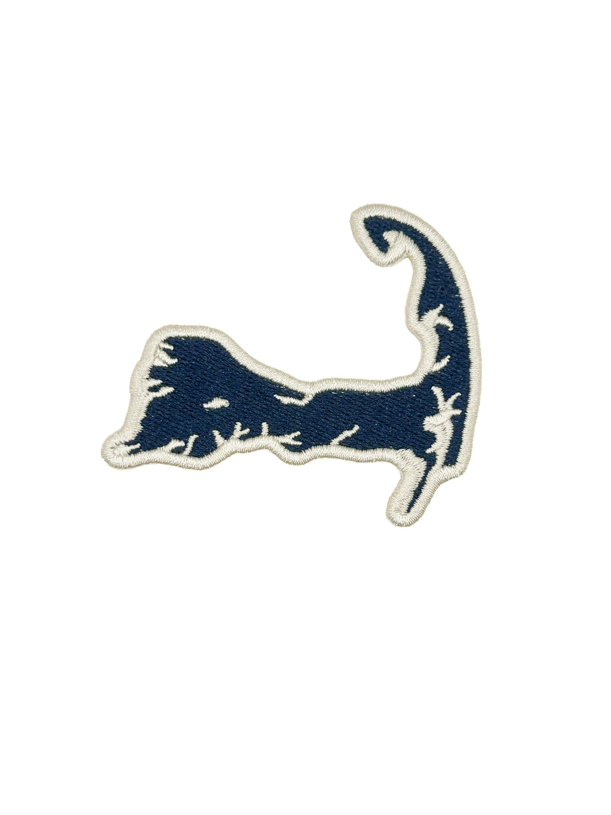 An embroidered patch shaped like the Cape Codic seal, featuring a navy blue design with a white embroidered border on a solid white background.