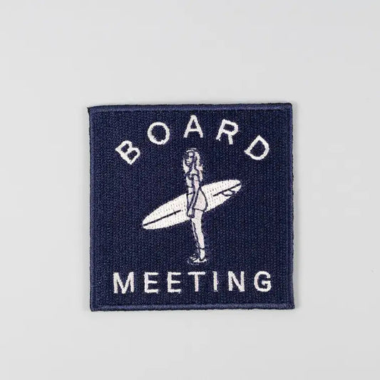 Patch with 'Board Meeting' text and a graphic of a person holding a surfboard on a gray background