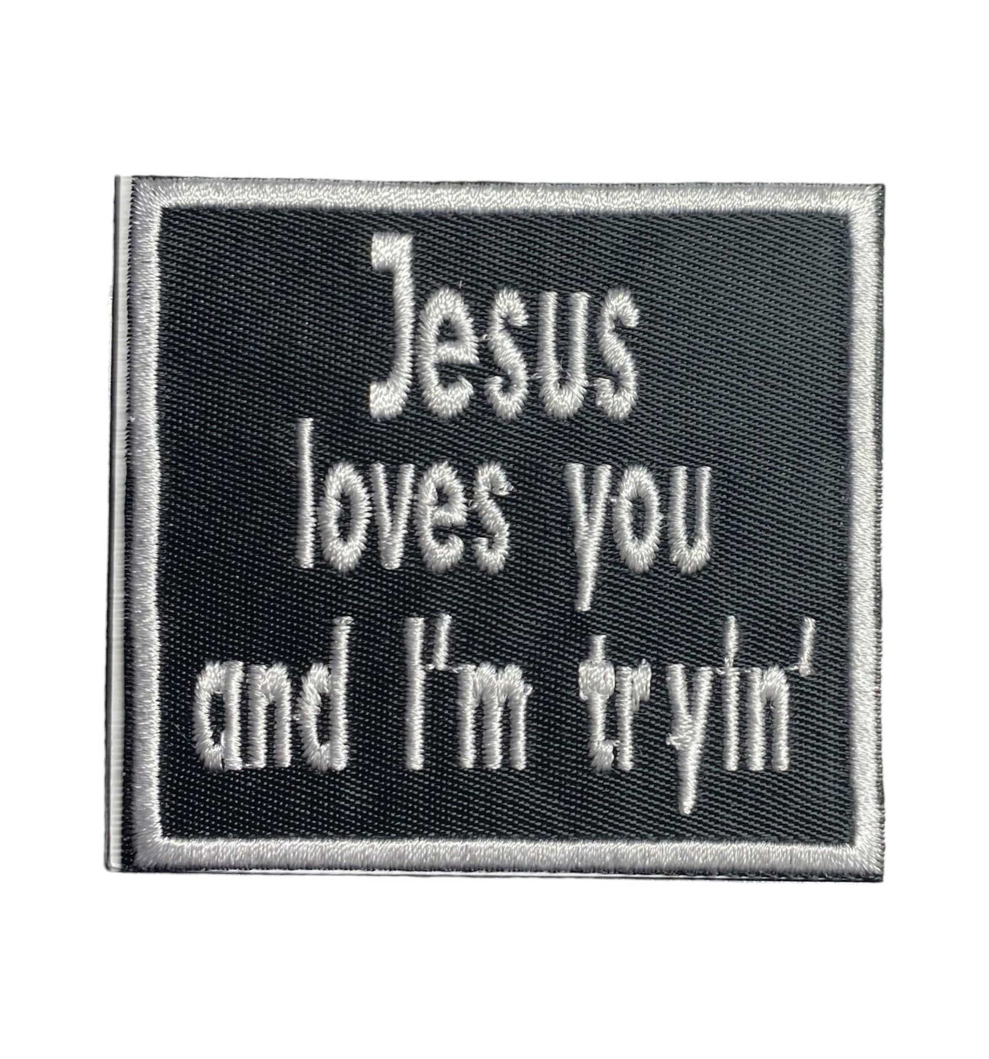 Embroidered patch with text 'Jesus loves you and I'm tryin'' on a black background