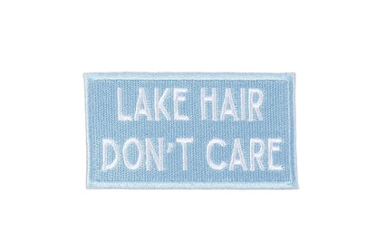 Embroidered patch with 'Lake Hair Don't Care' text on a beige background