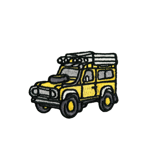 Embroidered patch of a yellow SUV with roof racks on a white background