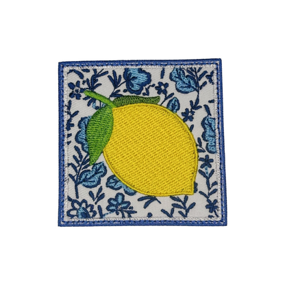 Embroidered patch with a lemon on a floral background